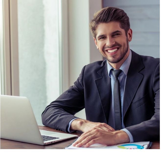 A man sitting at a table with his hands on the keyboard of a laptop.